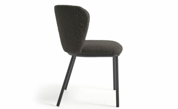 Cadeira Ciselia Preto, estofada com tecido efeito cordeiro na cor preta. Estrutura de metal com acabamento pintado preto mate para um design moderno e elegante.