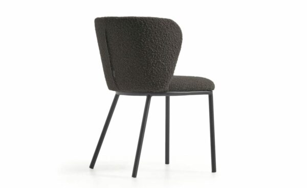 Cadeira Ciselia Preto, estofada com tecido efeito cordeiro na cor preta. Estrutura de metal com acabamento pintado preto mate para um design moderno e elegante.