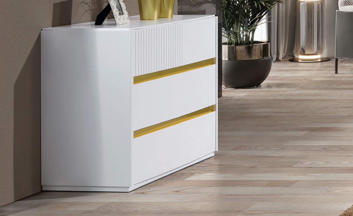 Cómoda Atlas com três gavetas, frisos geométricos e acabamento metálico